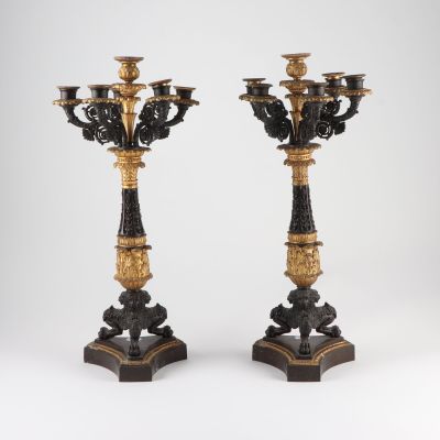 pair of black and gold candelabs on stands on a white background