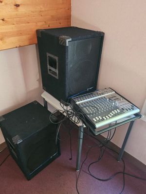 two speakers and a keyboard on a table in a room