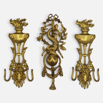 three antique brass wall sconces on a white background