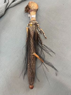 a small doll with a long hair and a hat on it ' s head