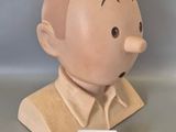 a wooden bust of a man with a name tag on it