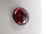 a close up of a red diamond on a white surface