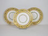 four yellow and white plates with floral designs on them