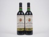 deux bouteilles de vin posées l'une à côté de l'autre sur une surface blanche