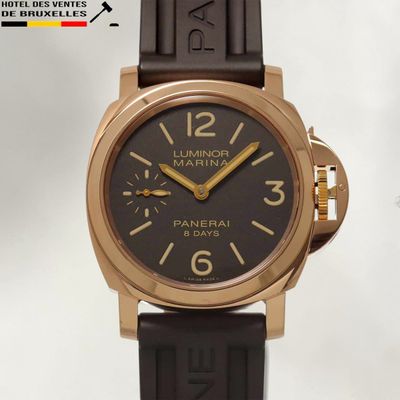 une montre noire et dorée montée sur un bracelet en caoutchouc noir