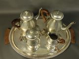 a silver tea set on a silver tray on a table