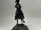 statue of a man riding a horse on a rock on a white background