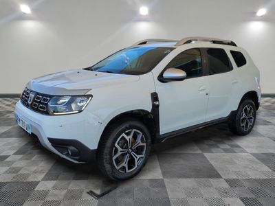 une Dacia blanche garée dans une pièce au sol carrelé