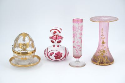 quatre vases différents et un petit œuf posés sur une table