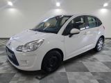 la petite voiture blanche est garée sur un sol en damier