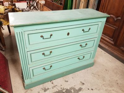 une commode bleue à quatre tiroirs dans une pièce