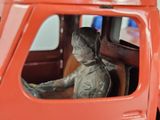 a statue of a boy sitting in the driver ' s seat of a toy truck