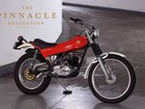 a red motorcycle parked in front of a white wall