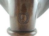a bronze vase with a medallion on the top of it