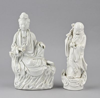 deux figurines blanches représentant un homme et une femme assis sur un rocher