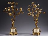 paire de chandeliers anciens en laiton ornés de fleurs, sur des socles en marbre