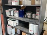 many cans of paint on the shelves in the garage