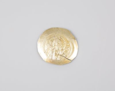 a close up of a gold coin with a picture of a woman on it