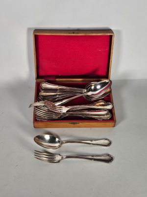 des couverts dans un coffret en bois avec un couvercle rouge et des cuillères