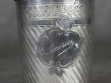 une coupe en argent posée sur une table près d'un mur