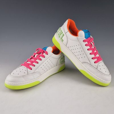une paire de baskets blanches avec des lacets rose fluo
