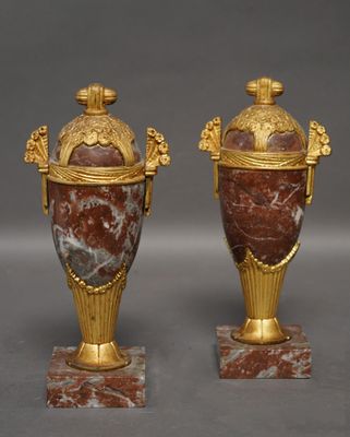 paire d'urnes en marbre doré et rouge reposant sur des socles en marbre