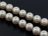 un gros plan sur un collier de perles blanches posé sur une surface noire