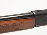 a close up of a rifle with a wooden handle on a white background