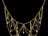 un collier en or orné de perles et de chaînes sur fond noir