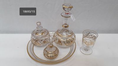 a glass tray with a glass decanter and a glass cup on it