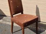 a brown chair sitting in front of a white wall