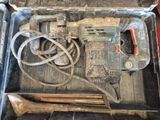 un outil dans une boîte à outils, à côté d'un marteau et d'autres outils