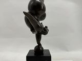 bronze sculpture of a person on a black marble base