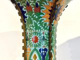 a green vase with a design on it on a table
