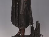 bronze statue of a woman with a dog on a pedestal