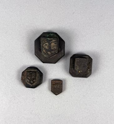 three pieces of metal with a face on them on a white surface