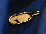 a close up of a gold dog tag on a blue shirt