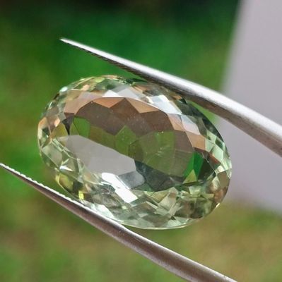 une pierre précieuse verte maintenue par une paire de pinces