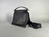 a black leather handbag with a gold buckle on the handle