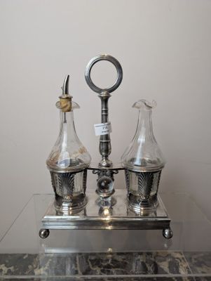 three glass vases on a table with a clock on it