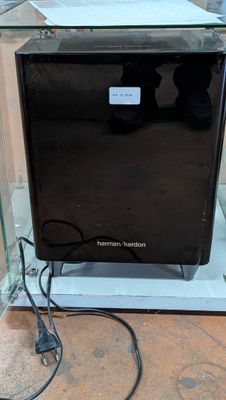 a black microwave sitting in a glass box on the floor