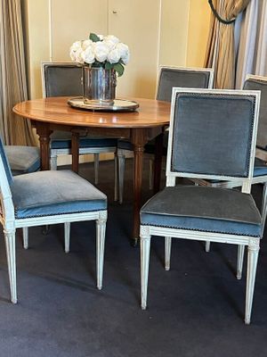 four chairs around a table with a vase of flowers on it
