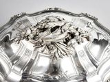a silver plate with a bird on it on a table