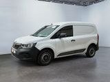 La camionnette blanche est garée dans une grande pièce aux murs blancs.