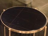 a black table with a gold base in a living room