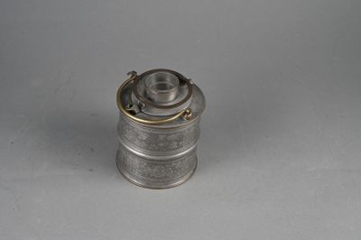 an old silver metal canister with a handle on a white surface