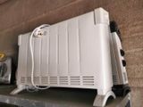 a white heater sitting on top of a shelf next to a wall