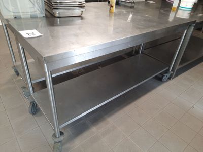 a large stainless steel table with a bunch of dishes on it