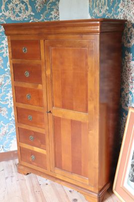 a wooden cabinet with drawers and a picture on the floor