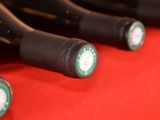 several bottles of wine are lined up on a red surface